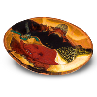 This is a 9-inch oval plate in beautiful earth tone colors accented with red.  It is high-fired stoneware clay.  Handmade pottery by Prairie Fire Pottery.  Hand made in the U.S.A.  3/4 table top view.