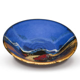 Large 13 inch stoneware bowl in cobalt blue and toasted orange colors, accented with red.  Handmade pottery by Prairie Fire Pottery.  This is a 3/4 view of the piece.