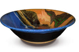 Large 13 inch stoneware bowl in cobalt blue and toasted orange colors, accented with red.  Handmade pottery by Prairie Fire Pottery.  This is a side view showing its shape and contour.