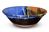 12 inch wheel-thrown pottery bowl in cobalt blue and toasted brown colors.  High-fired stoneware handmade by Prairie Fire Pottery.  This is a side view of the bowl.