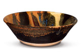 Handmade pottery bowl.  12 inch diamenter.  Earth tone and red colors accented with a ribbon of blue.  Handmade by Prairie Fire Pottery.  Side view of the bowl.