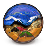A 7-inch medium bowl with a blend of toasted orange, cobalt blue, red, crystal yellow, and white colors, wheel-thrown in stoneware clay and high-fired.  Handmade pottery by Prairie Fire Pottery.  Over head view.