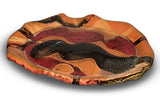14 inch hand built stoneware plate in pretty earth tone colors and red. Handmade pottery by Prairie Fire Pottery. Kiln-fired to 2400°. Hand made in the U.S.A. This is a 3/4 table top view of the plate.