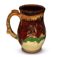 Gorgeous handmade takard mug in earth tone and red colors.  Handmade pottery.  Hand made by Prairie Fire Pottery in stoneware clay fired to 2400°.  Left side view.