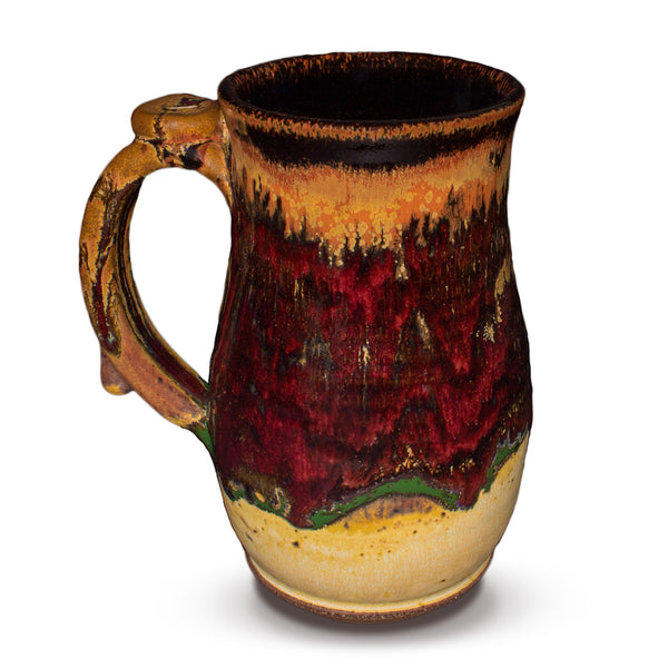 Left side view of a handmade pottery stoneware mug is earth tone and red colors.  It is hand made and wheel-thrown by Prairie Fire Pottery.  Made in the U.S.A