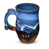 Handmade pottery mug in cobalt blue and toasted brown. Wheel-thrown and high-fired to 2400° by Prairie Fire Pottery. Will quickly become your favorite morning coffee cup.  Left sideview.