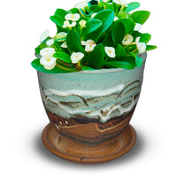 Small planter with a 4 inch diameter. Ideal for succulents. Glazed in turquoise and brown colors. Handmade pottery by Prairie Fire Pottery. Hand made in the U.S.A. View of the planter holding a succulent plant.