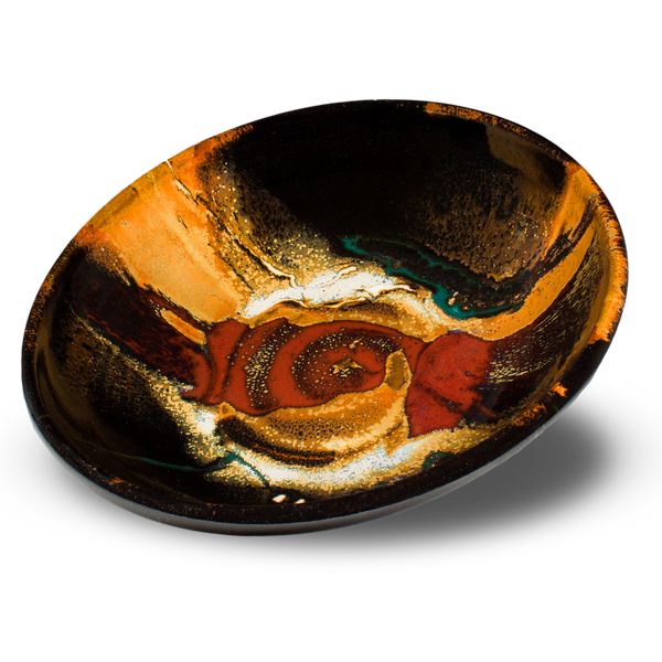 9-inch wheel-thrown stoneware bowl in toasted orange and red colors set against a black background. Handmade pottery by Prairie Fire Pottery. Hand made in the U.S.A.  3/4 tabletop view.