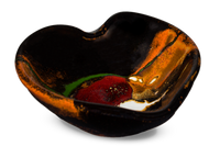 Heart-shaped bowl in toasted orange and black with red accents. Handmade pottery by Prairie Fire Pottery.  3/4 view.