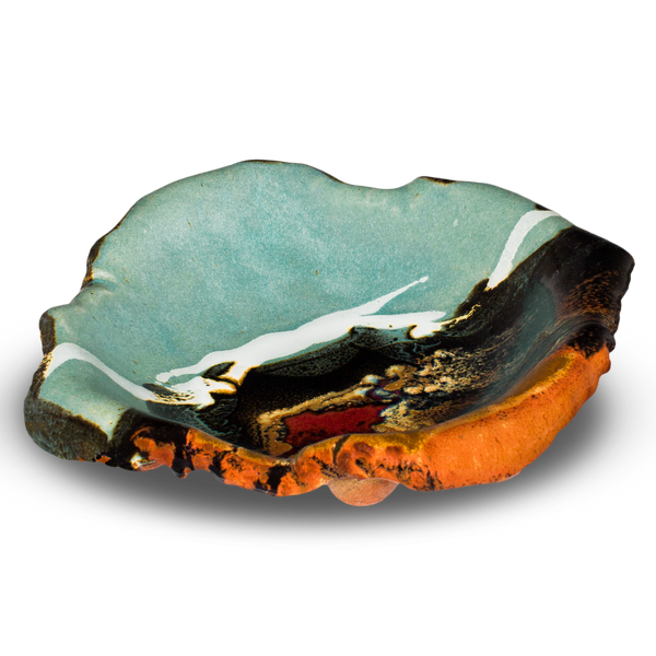 This is a 9 1/2 inch hand built bowl in turquoise and brown glazed color, accented with red.  Handmade pottery stoneware clay by Prairie Fire Pottery.  This is the 3/4 table top view of the product.