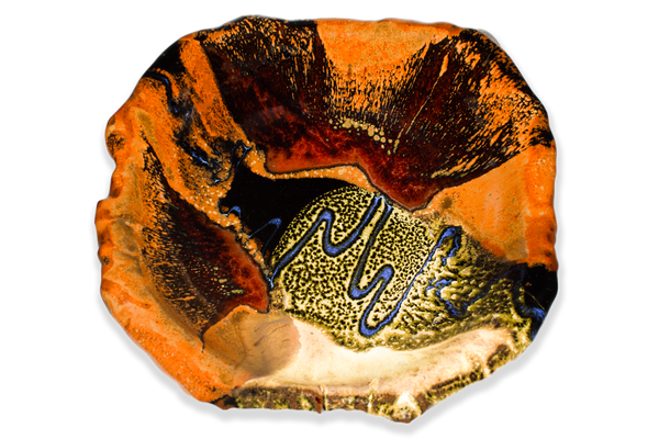 9" hand built bowl in earth tones and blue. Handmade pottery. Overhead view.