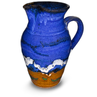 52 ounce wheel-thrown pitcher in cobalt blue and toasted brown.  Handmade pottery by Prairie Fire Pottery.  Hand made in stoneware clay and high-fired to 2400°.  Left side view.