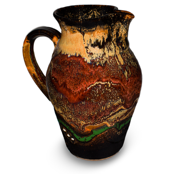 56 ounce wheel-thrown pitcher in earth tone colors over black.  Handmade pottery crafted in stoneware clay by Prairie Fire Pottery.  Left side view.