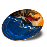 14 inch round serving platter in cobalt blue and toasted orange colors. Handmade pottery by Prairie Fire Pottery. High-fired stoneware clay. Hand made in the U.S.A. 3/4 table top view.