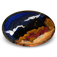 Cobalt blue and toasted brown lunch plate with red accent colors.  Handmade pottery by Prairie Fire Pottery.  3/4 side view.