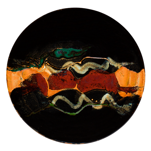 A beautiful blend of colors in this 14 inch platter. Glazed in toasted orange on black with gold, green, and blue accents. Handmade pottery from the studio of Prairie Fire Pottery. Hand made in stoneware clay in the U.S.A.  Overhead view.