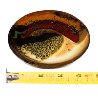 Small round plate in beautiful earth tone colors and red.  It's handmade pottery by Prairie Fire Pottery.  Hand crafted in stoneware clay and high-fired to 2400°.   Side view with ruler.