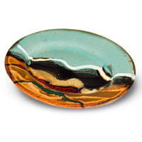 9-inch oval stoneware plate.  Turquoise-brown accented with red and teal.  Handmade pottery from Prairie Fire Pottery.  Hand made in the U.S.A.  3/4 table top view.