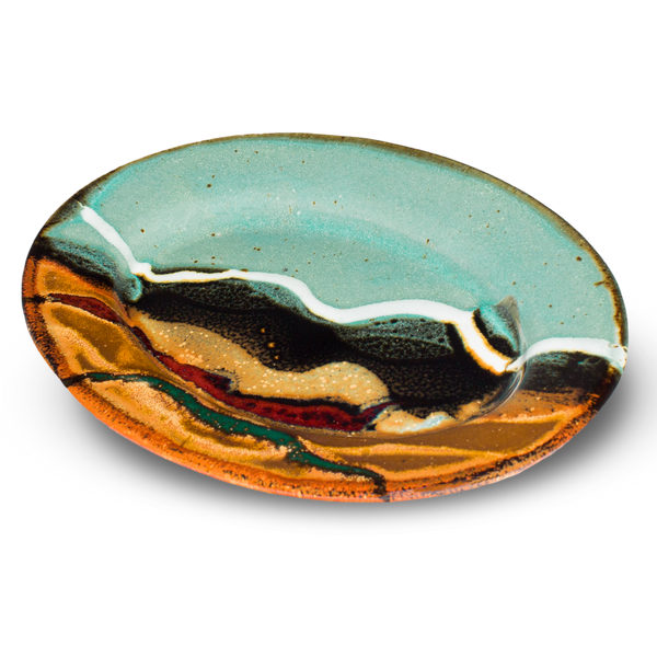 9-inch oval stoneware plate.  Turquoise-brown accented with red and teal.  Handmade pottery from Prairie Fire Pottery.  Hand made in the U.S.A.  3/4 table top view.